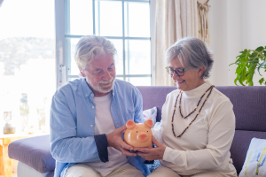 Couple reviewing hold a piggy bank representing their TSP Roth.